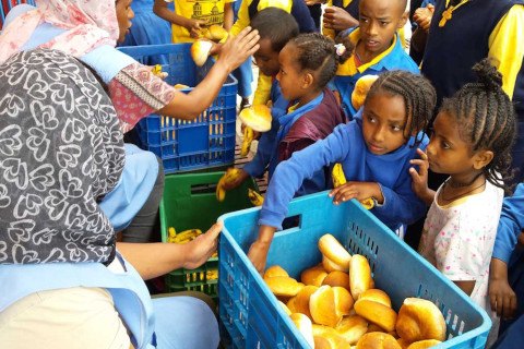 Kids taking loafs of bread